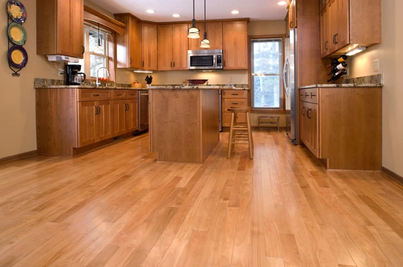 A modern kitchen with light-colored hardwood floors.