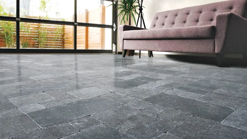 A modern living room with a grey stone floor featuring a patterned design