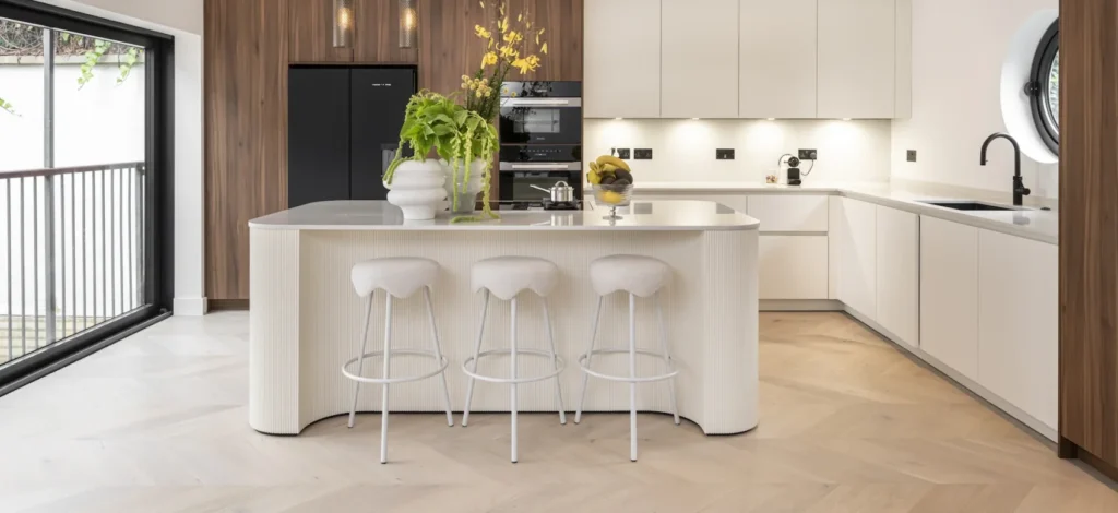 A modern kitchen featuring light-colored chevron wood flooring