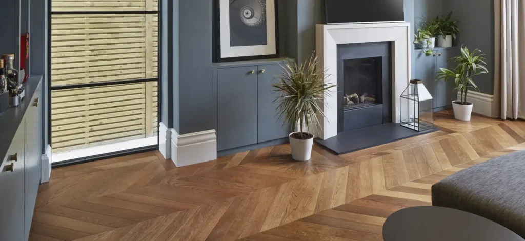 A room with dark chevron wood flooring
