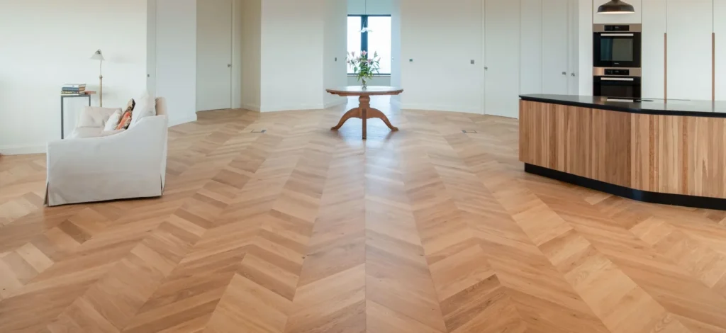 A spacious room featuring oak herringbone chevron wood flooring