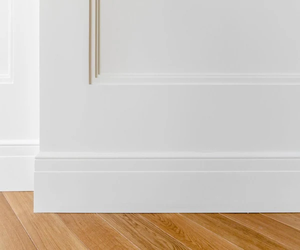 White skirting board on wooden floor